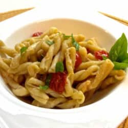 A square bowl of Gemelli Pasta with Tomatoes, Basil and Garlic