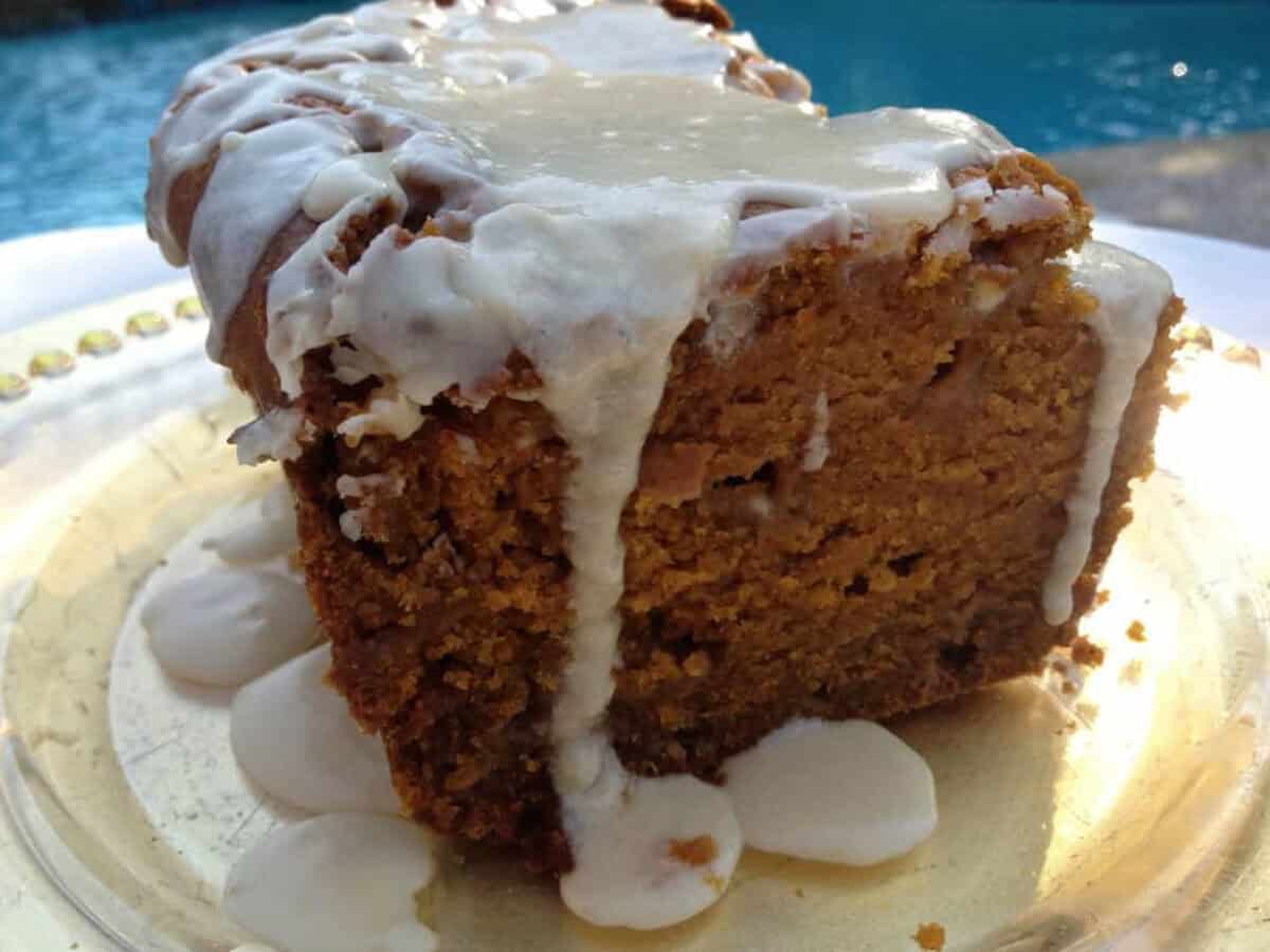 Spiced Pumpkin and White Chocolate Bread With Maple Glaze from Zagleft Spiced Pumpkin and White Chocolate Bread topped with a Maple Glaze on a plate with a pool in the background