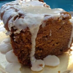 Spiced Pumpkin and White Chocolate Bread topped with a Maple Glaze on a plate with a pool in the background