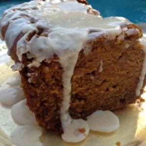 Spiced Pumpkin and White Chocolate Bread topped with a Maple Glaze on a plate with a pool in the background