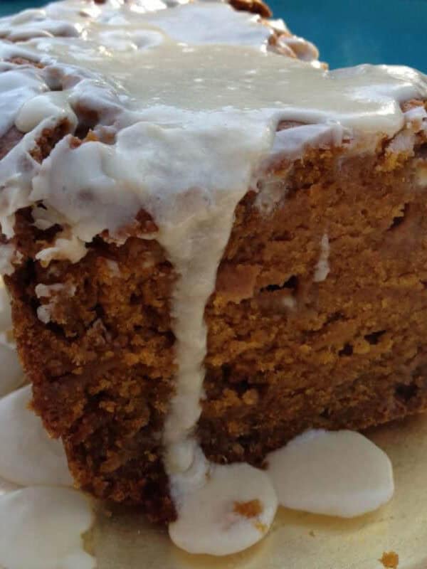 Spiced Pumpkin and White Chocolate Bread topped with a Maple Glaze on a plate with a pool in the background