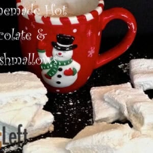 Homemade marshmallow squares scattered around a mug of hot chocolate