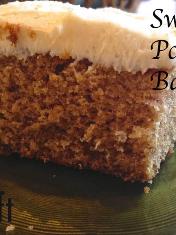 A square slice of a sweet potato bar topped with white icing on a small plate