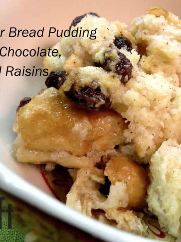 A closeup of a bowl of Slow Cooker Bread Pudding with white chocolate, pecans, and raisins