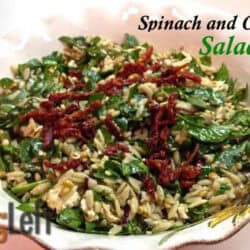 Spinach and Orzo Salad topped with feta cheese crumbles in a large serving bowl