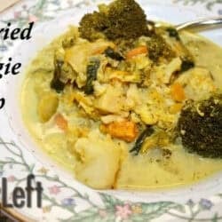 A bowl of Curried Veggie Soup with thick pieces of cauliflower, broccoli, carrots, sweet potatoes, spinach and sweet apples.