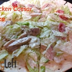 Thin crust pizza topped with a chicken caesar salad