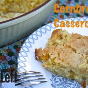 A square slice of Cornbread Casserole on a plate next to the remainder of the casserole in a serving dish