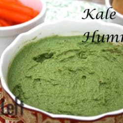 A bowl of Kale Hummus plated next to a small bowl of baby carrots