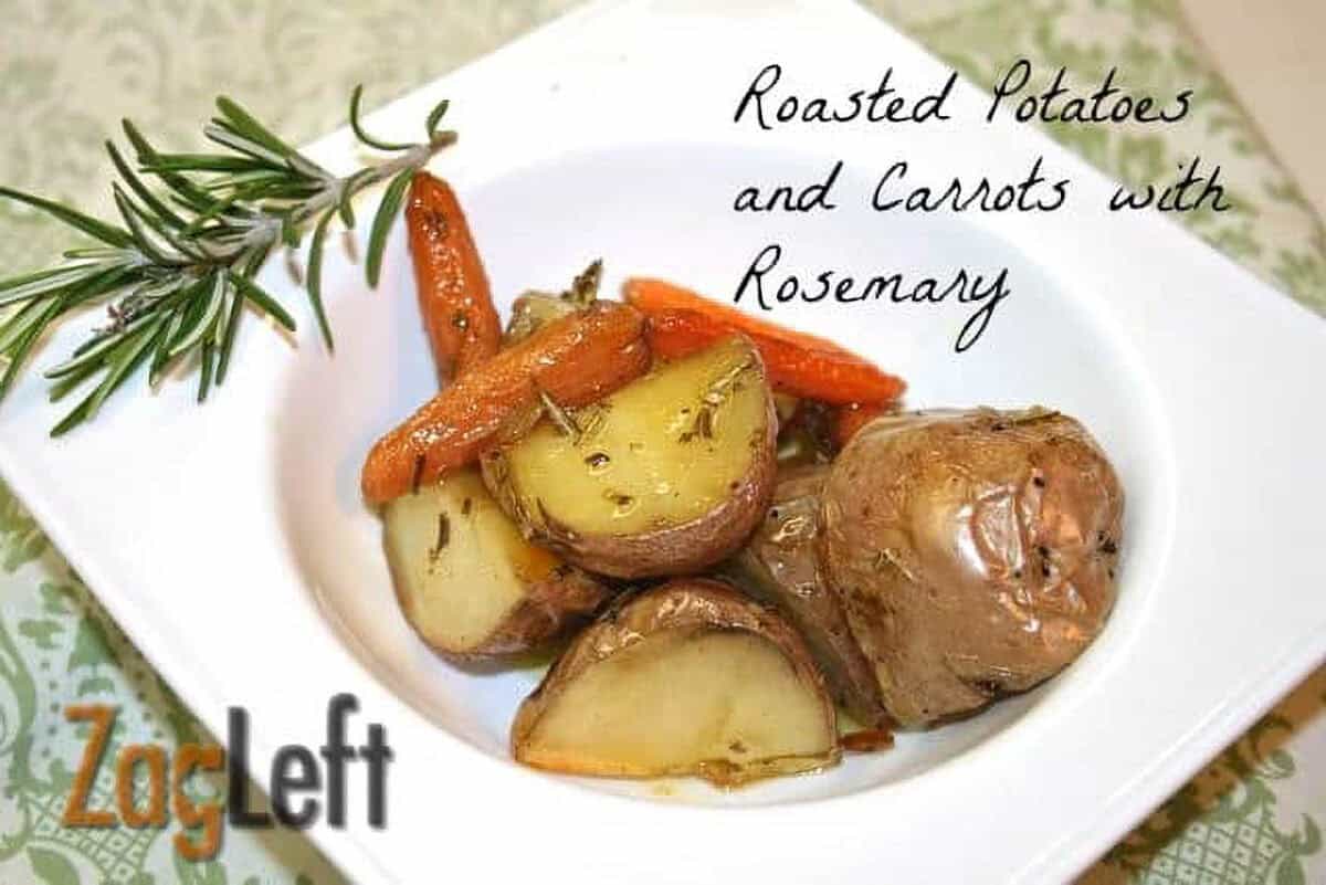 Seasoned oven roasted chopped potatoes and carrots in a square bowl garnished with a sprig of rosemary