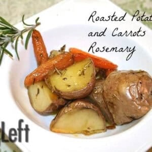 Seasoned oven roasted chopped potatoes and carrots in a square bowl garnished with a sprig of rosemary