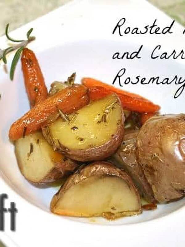 Seasoned oven roasted chopped potatoes and carrots in a square bowl garnished with a sprig of rosemary