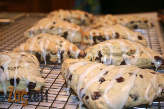 Dark Chocolate Orange Scones drizzled with white icing on a cooling rack