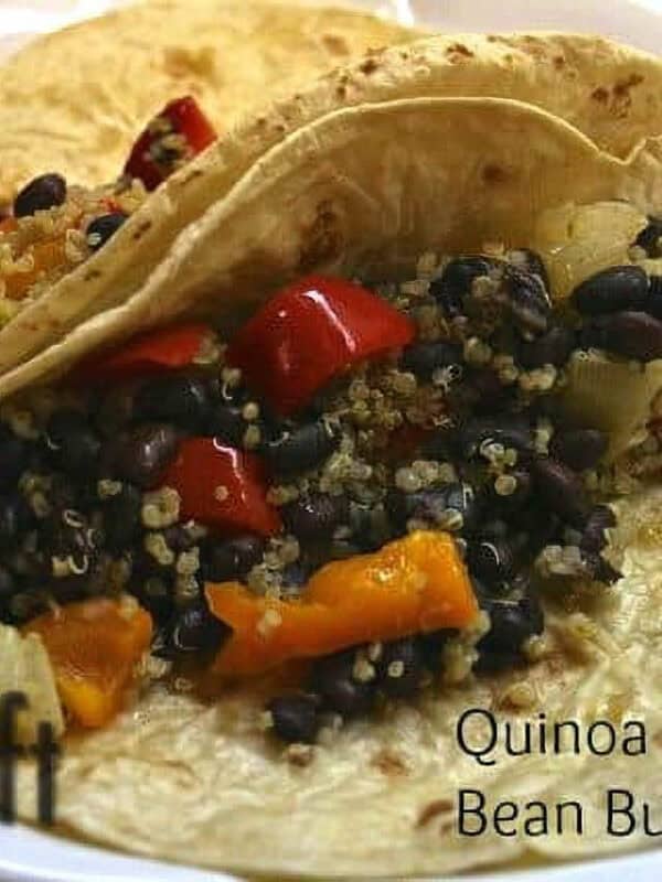 a plate of Two Quinoa and Black Bean Burritos with chopped orange and yellow bell peppers on flour tortillas
