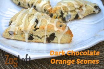 Three Dark Chocolate Orange Scones drizzled with white icing on a large plate