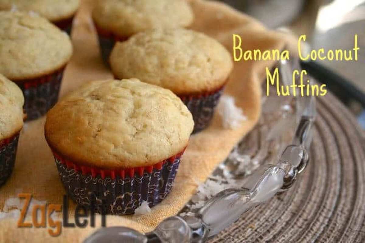 Six Banana Coconut Muffins on a large glass plate with coconut shavings