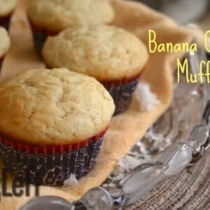 Six Banana Coconut Muffins on a large glass plate with coconut shavings