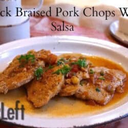Four Quick Braised Pork Chops topped With Salsa on an oval shaped plate next to a half stick of butter on a small plate