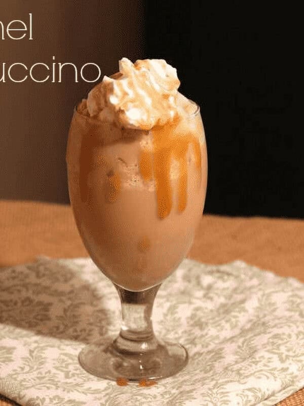 Caramel Frappuccino in a tall glass with whipped cream on top.