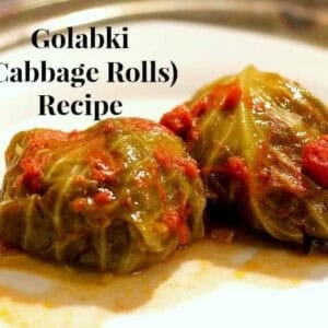 Two Golabki (Stuffed Cabbage Rolls) topped with crushed tomatoes on a plate