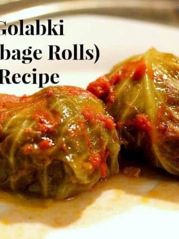 Two Golabki (Stuffed Cabbage Rolls) topped with crushed tomatoes on a plate