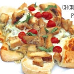 Sliced chicken with cheese and pesto on top of biscuits in the form of pizza.