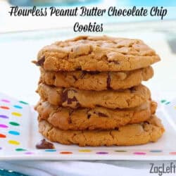 Five flourless peanut butter chocolate chip cookies stacked on a square polka dot plate
