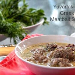 A bowl of Yuvarlakia - Greek Meatball Soup next to a bowl of dill and parsley.