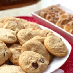 A large plate of Pecan Praline Cookies next to a dish of pecan pralines