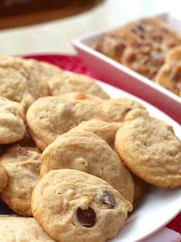 A large plate of Pecan Praline Cookies next to a dish of pecan pralines