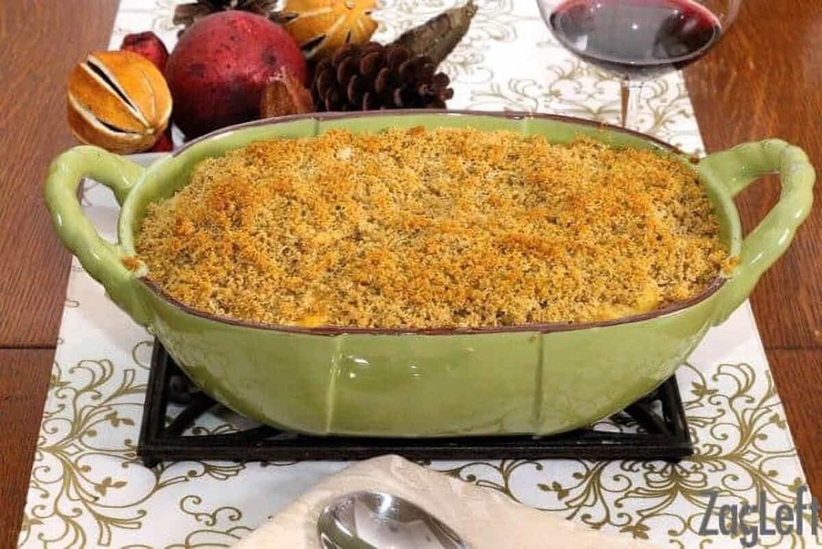 Sweet Potato Macaroni and Cheese in a large baking dish next to a glass of red wine