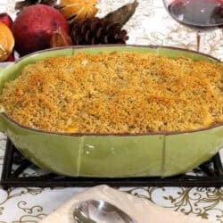 Sweet Potato Macaroni and Cheese in a large baking dish next to a glass of red wine