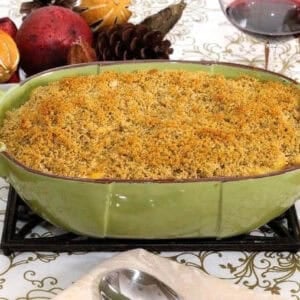 Sweet Potato Macaroni and Cheese in a large baking dish next to a glass of red wine
