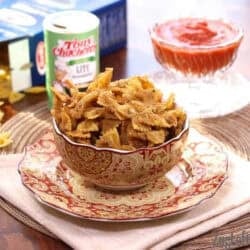 Fried Pasta in a bowl plated next to a container of cajun seasoning and a small bowl of Marinara sauce