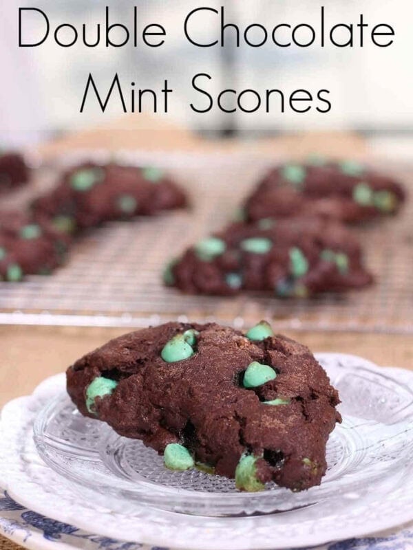 A Double Chocolate Mint Scone on a small plate with scones on a cooling rack in the background