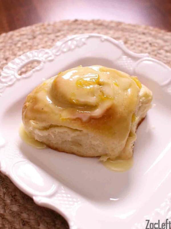 A Pineapple Sweet Roll topped with a glaze on a small plate