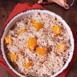 Spiced Butternut Squash Basmati Rice in a large bowl on top of a red cloth napkin and next to measuring spoons
