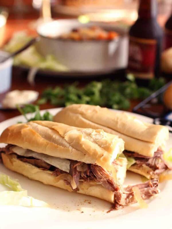 Two halves of a Roast Beef Po-boy on a large plate