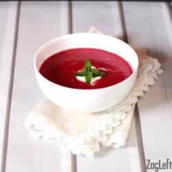 Borscht soup in a bowl topped with a dollop of sour cream