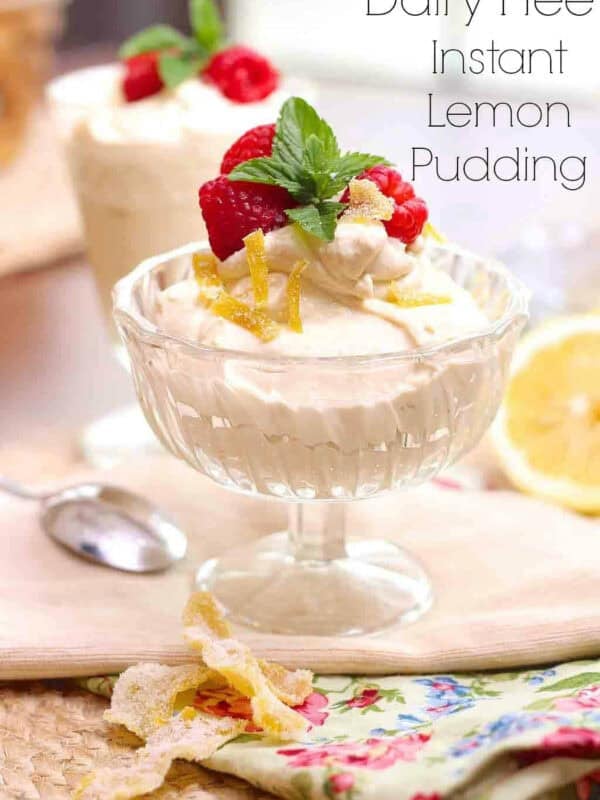 Dairy-Free Instant Lemon Pudding in a glass dessert glass topped with lemon zest, dairy-free whipped cream, raspberries, and mint