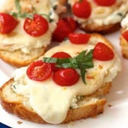 caprese toast with sliced tomatoes on a plate.